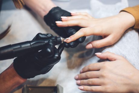 Manicure, Nails Polish Procedure. Professional hardware manicure using electric machine in beauty salon. master uses an electric machine to remove nail polish hands during manicure.